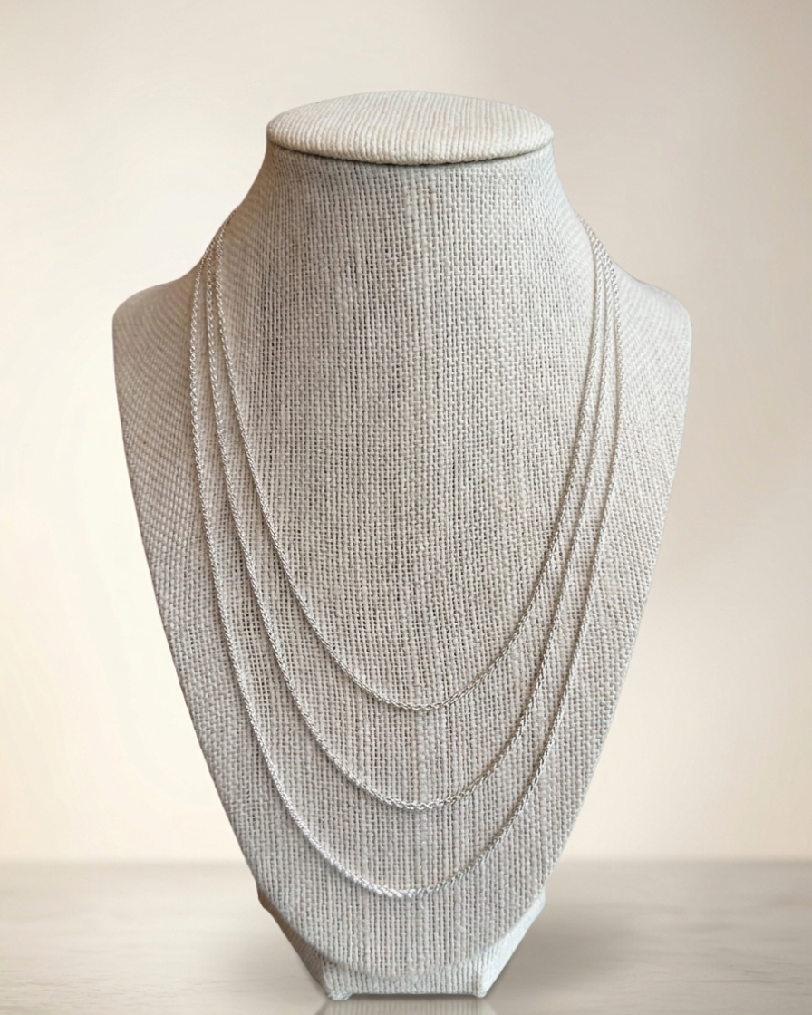 Sterling silver wheat chains on a fabric bust to show size length difference. 